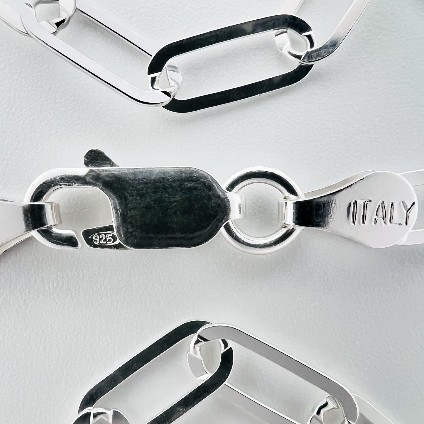 close up of closure with 925 silver stamp and clear pattern of paperclip style chain is visible