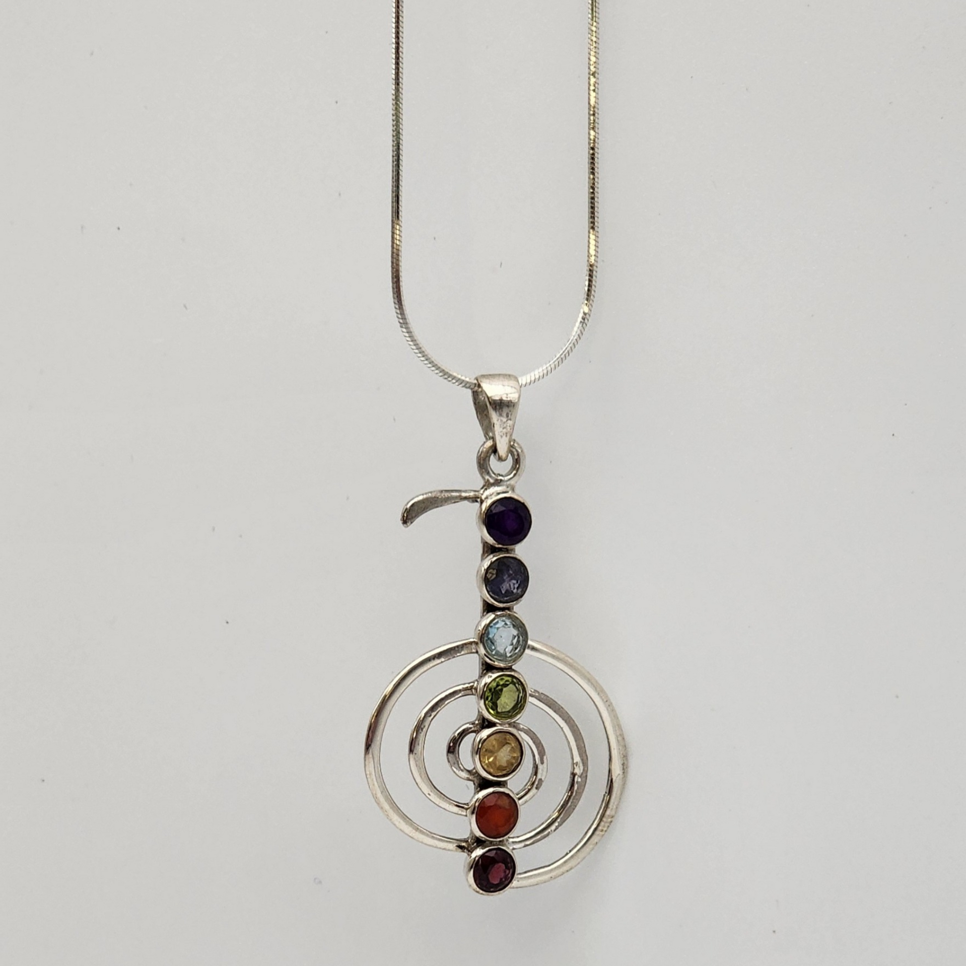 A single chakra pendant hanging from a silver snake chain.