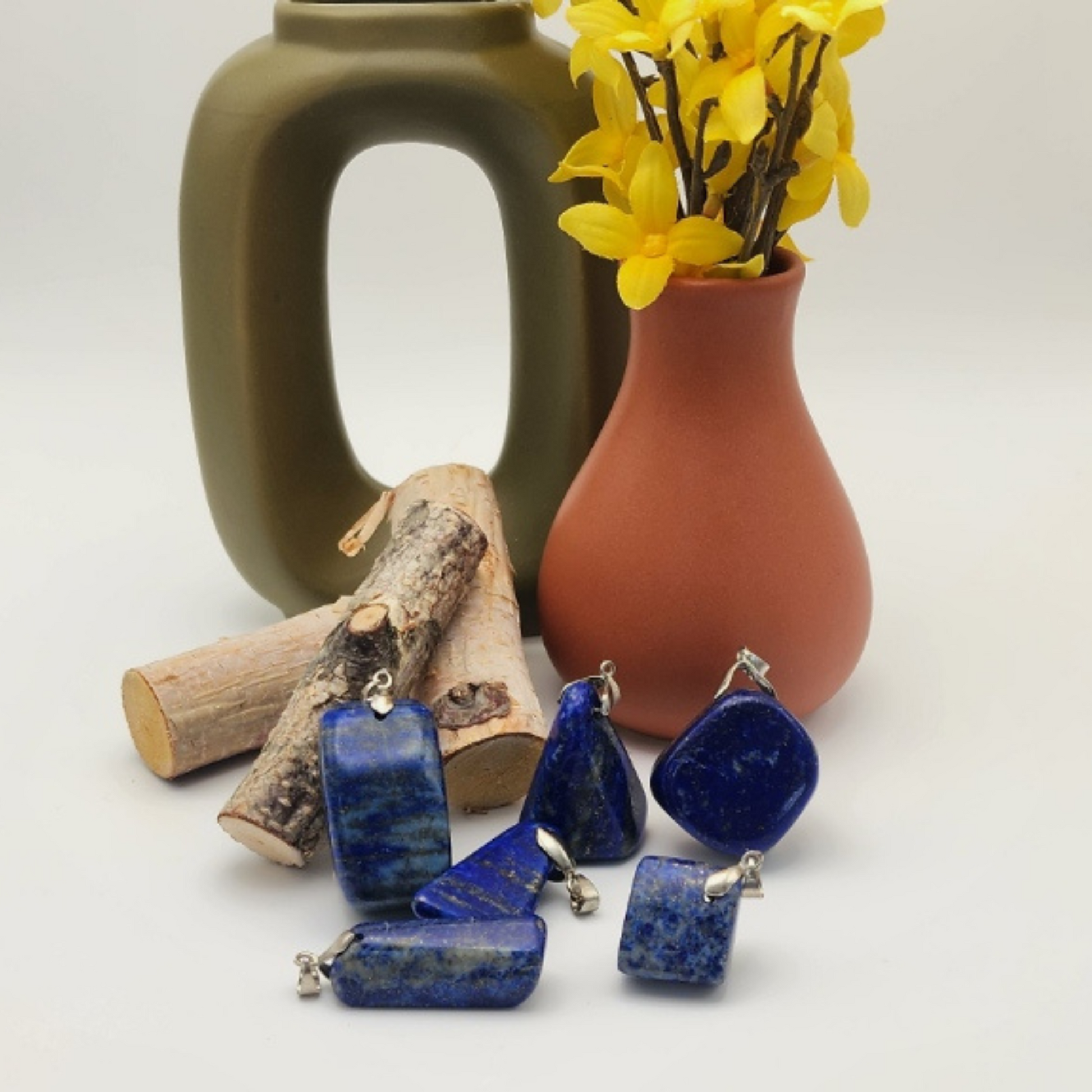 six Lapis lazuli pendants staged and arranged in a moody Bloom and Glow aesthetic.