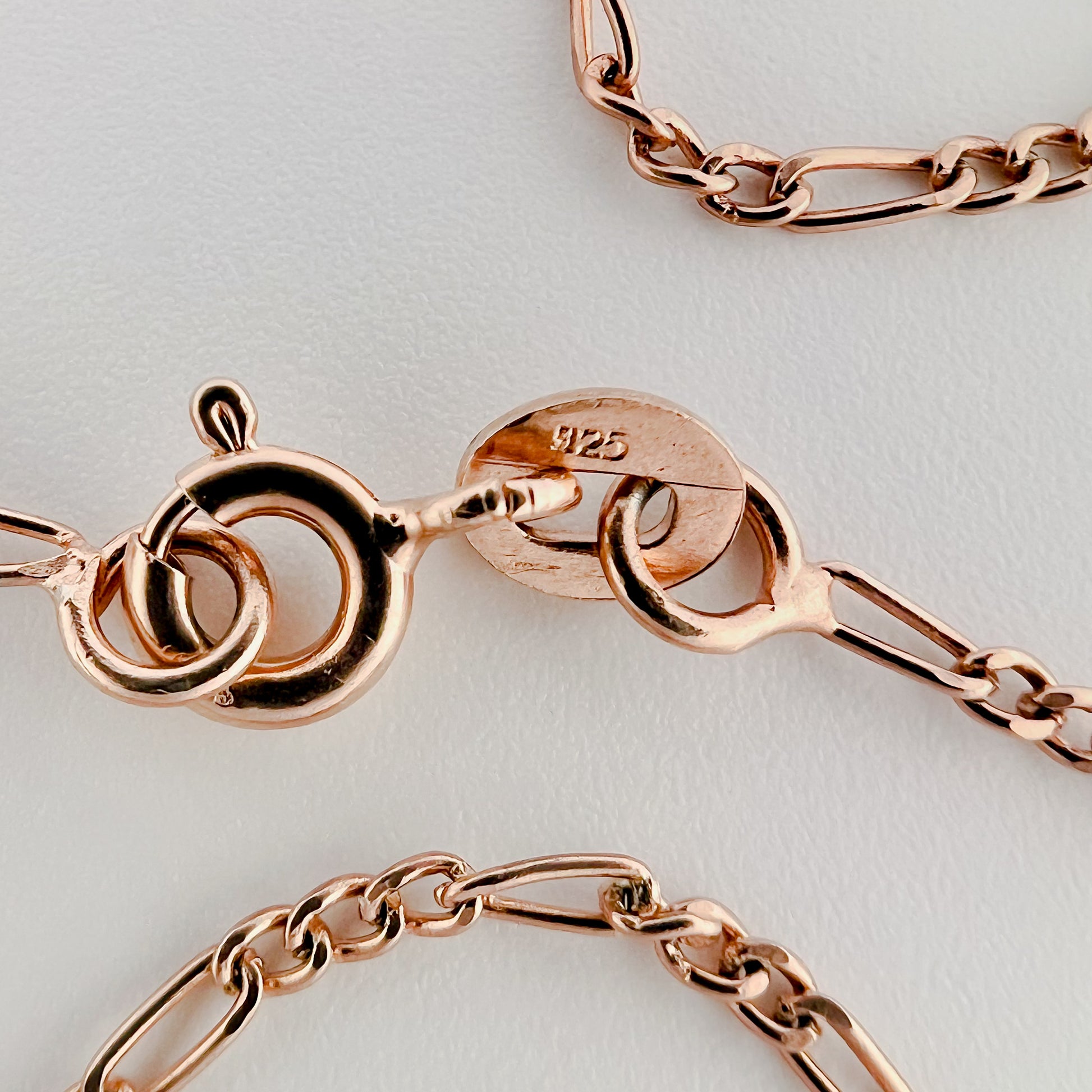close up of clasp with 925 silver stamp and clear pattern of figaro style chain is visible