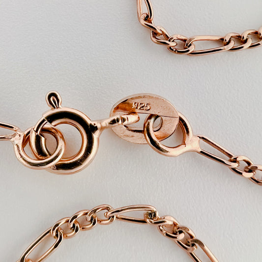 close up of clasp with 925 silver stamp and clear pattern of figaro style chain is visible