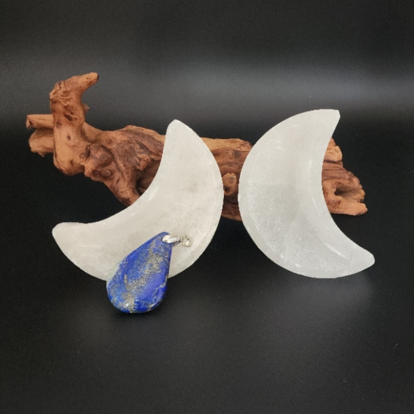 two crescent moon shaped selenite trinket bowls set in a Bloom and Glow moody aesthetic. 