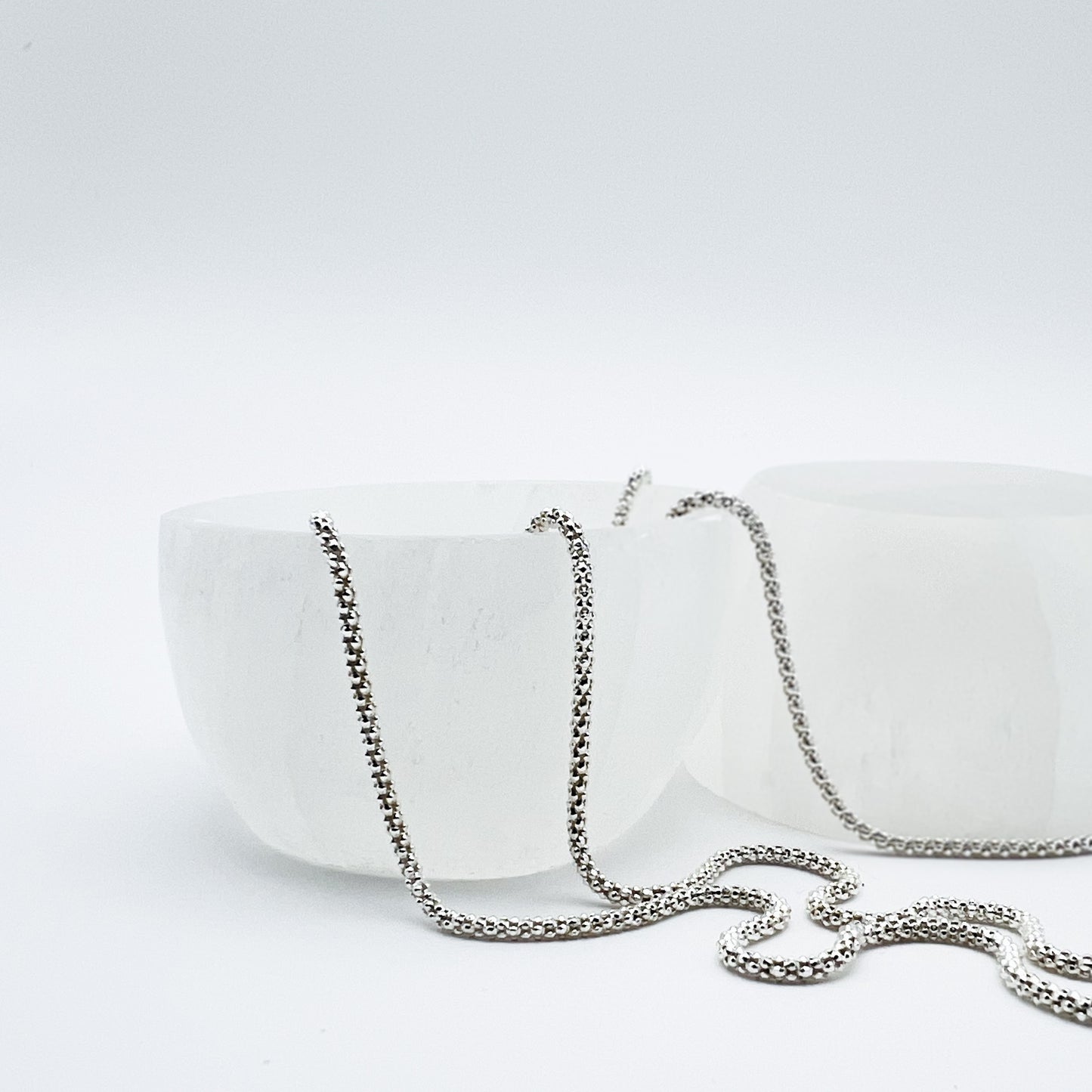 two small round selenite trinket bowls set in a Bloom and Glow moody aesthetic. 