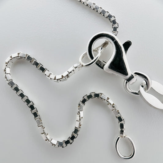 close up of closure with 925 silver stamp and clear pattern of box chain style chain and two adjustable closure points