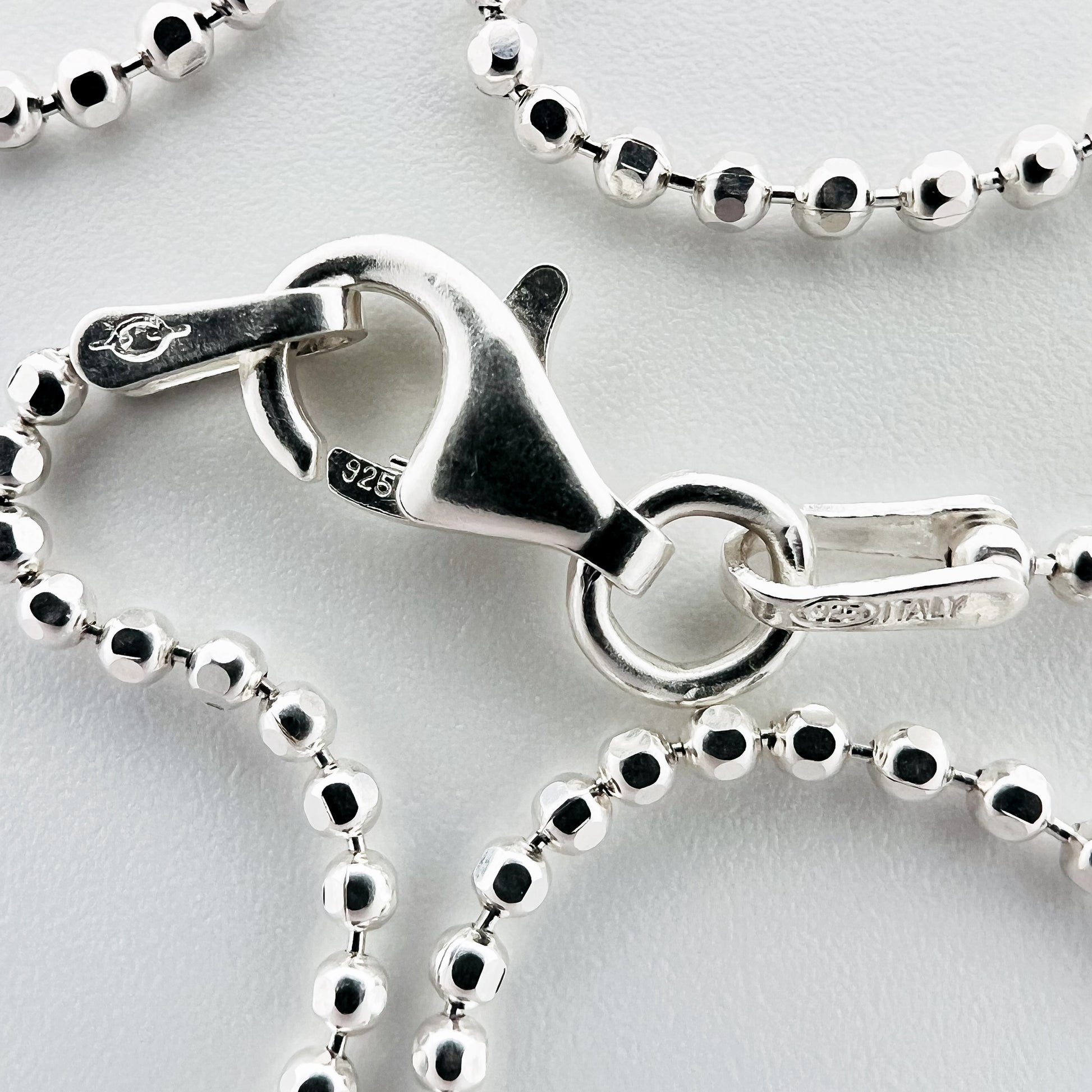 close up of closure with 925 silver stamp and clear pattern of ball style chain
