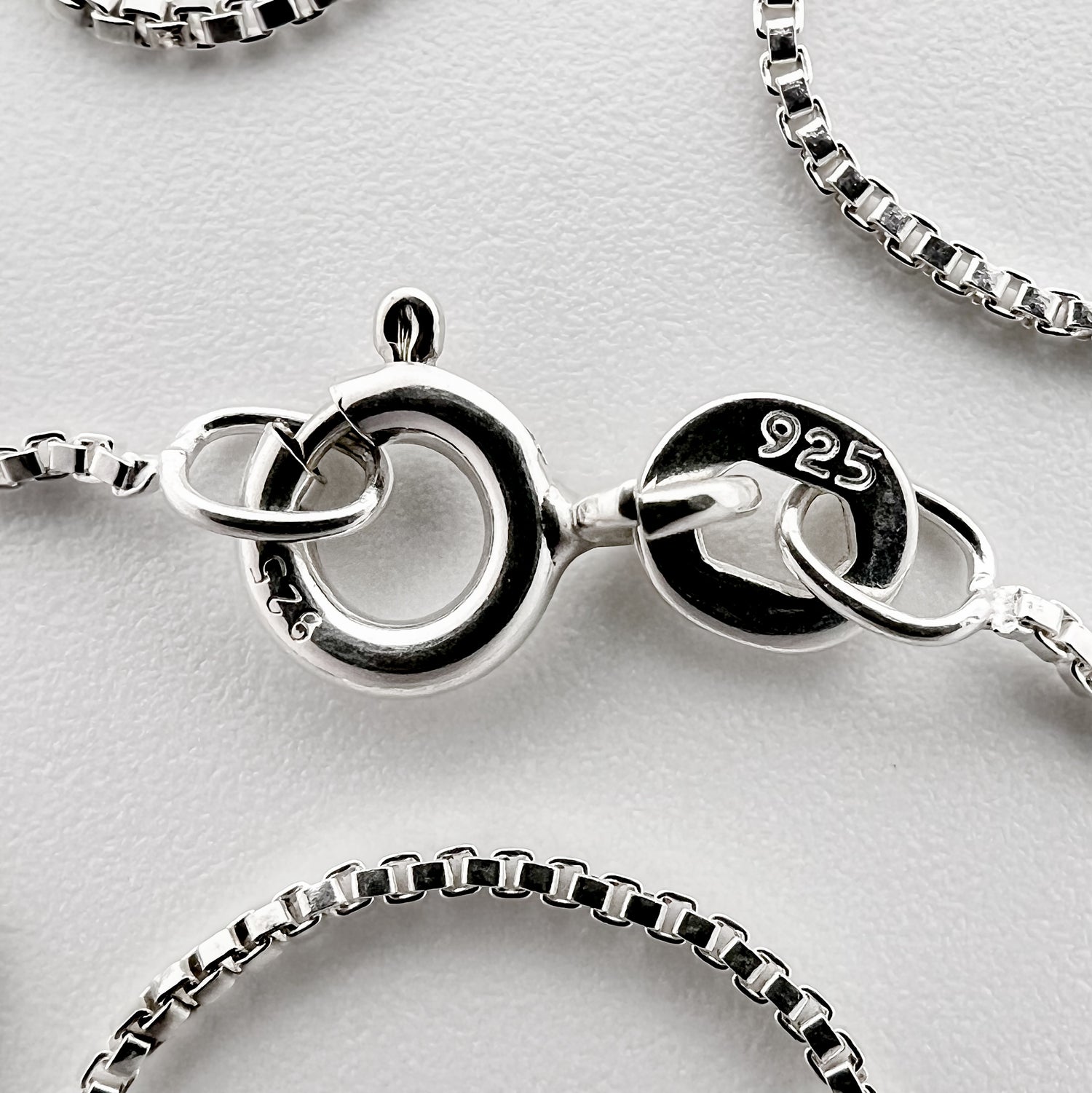 close up of clasp with 925 silver stamp and clear pattern of box style chain is visible