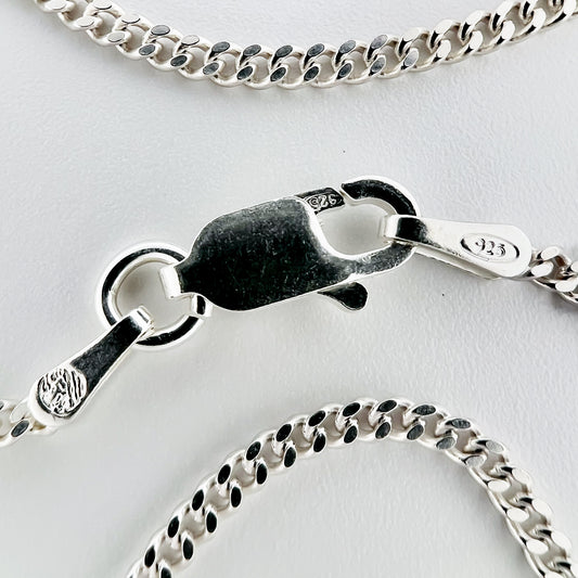 close up of clasp with 925 silver stamp and clear pattern of curb style chain is visible