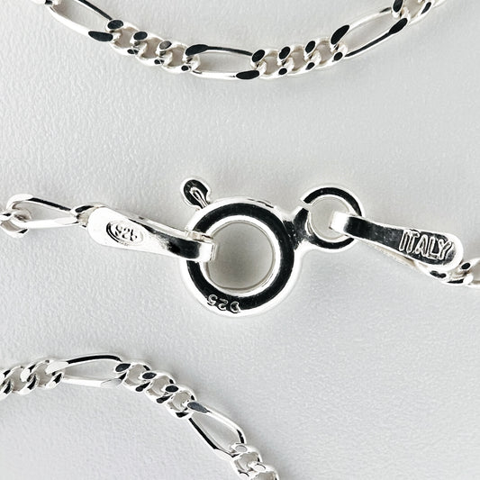 close up of closure with 925 silver stamp and clear pattern of figaro style chain is visible