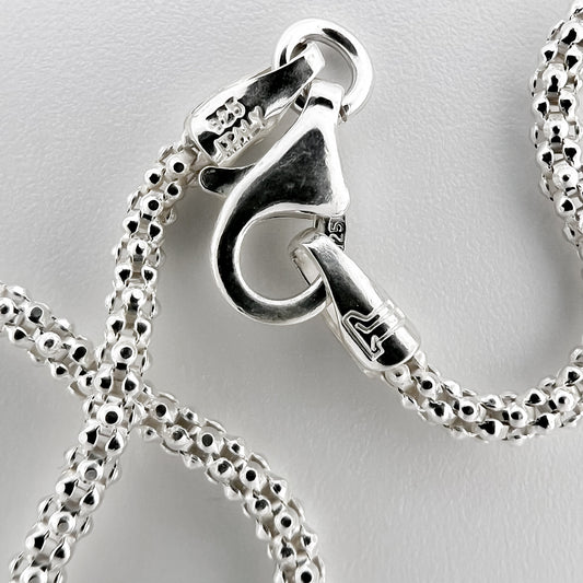 close up of closure with 925 silver stamp and clear pattern of popcorn style chain are visible