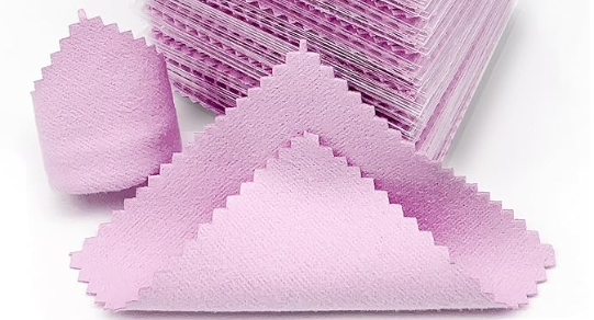 one stack of pink polishing cloths. There is one single cloth in front of the pile showing the texture of the mirco fiber. 